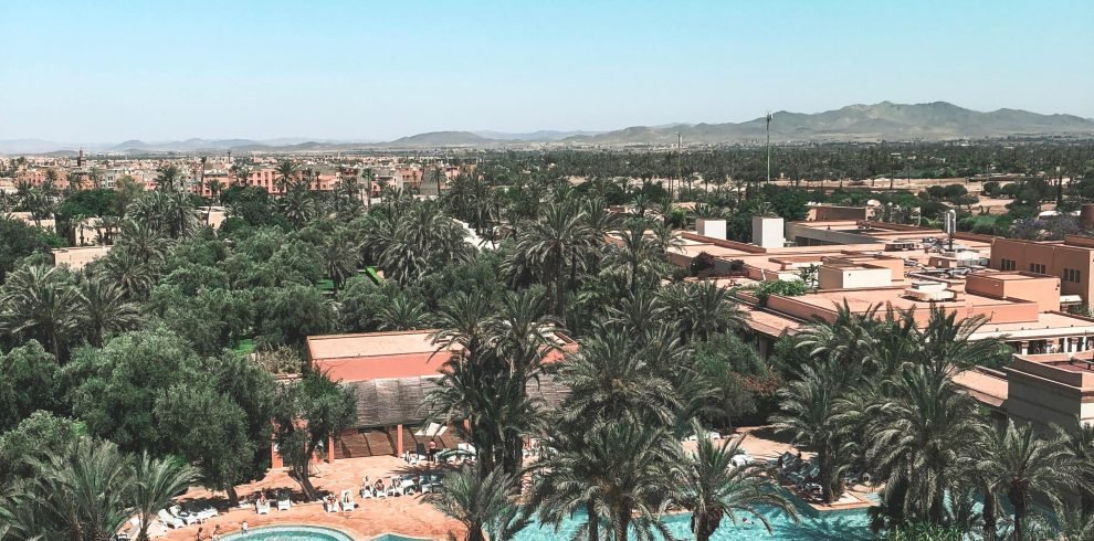 Aerial view of a luxurious tropical resort featuring a scenic swimming pool amidst lush greenery.