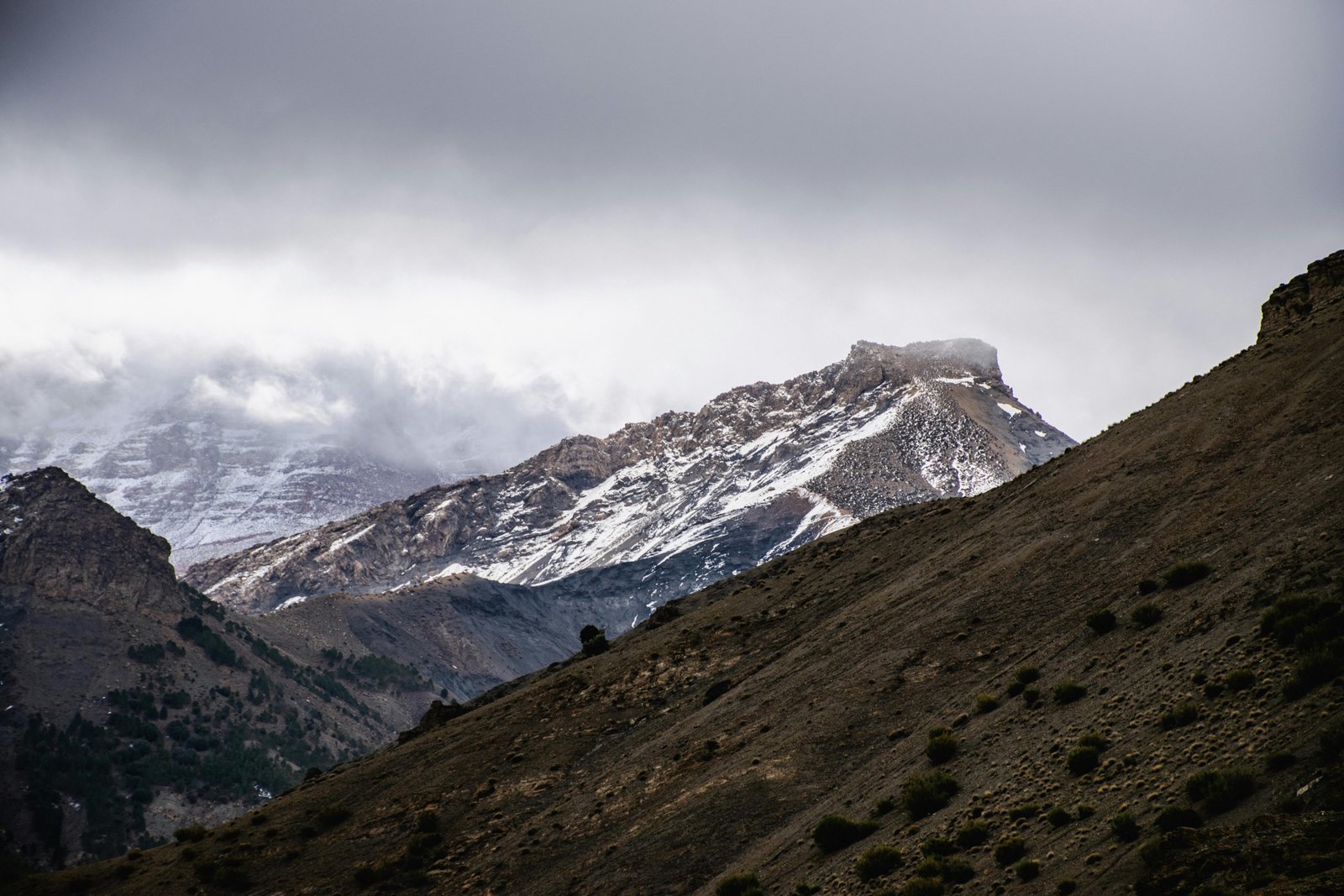 Captivating view of a snow-capped mountain under a cloudy sky, exuding serenity.
